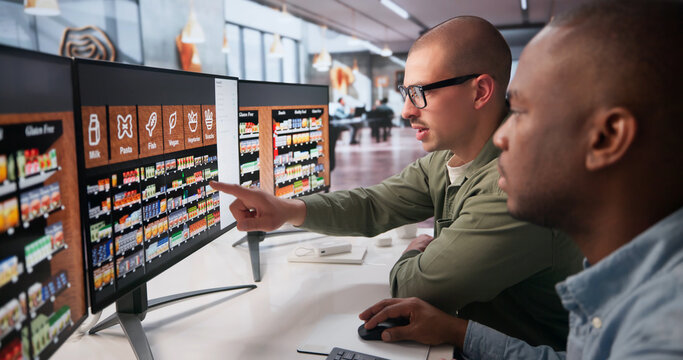 Two Retail Managers Working Together On Computer