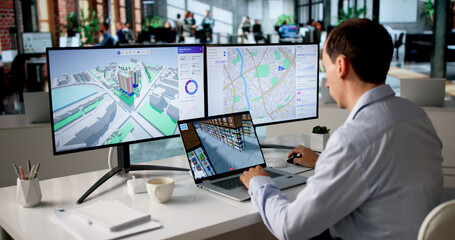 Naklejka premium Engineer Studies Urban Property Maps On Laptop Using BIM
