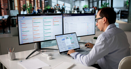 Man Monitors Compliance Dashboard On Laptop
