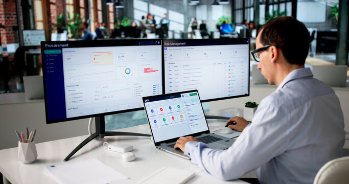 Man Uses Laptop To Track Procurement Progress