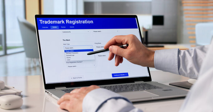 Man Using Laptop To Submit Trademark Application