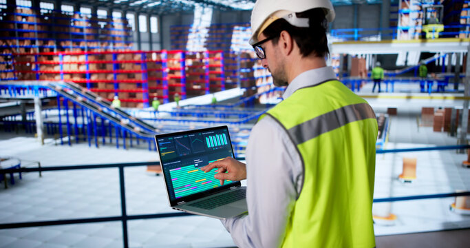 Warehouse Worker Uses Computer To Inspect Data