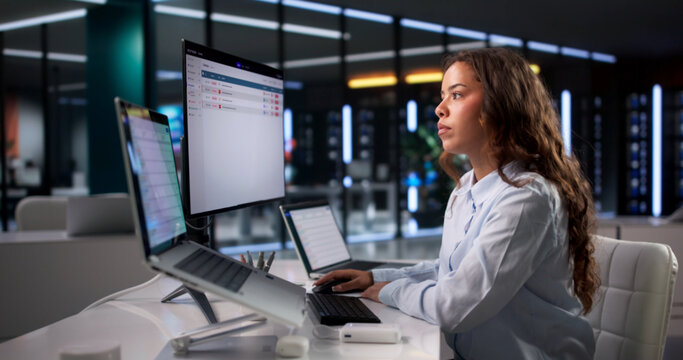 Young Woman At Desk Using Laptop