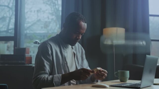 Confident man working, Calm man diligently typing spreadsheets and verifying messages at modern office desk