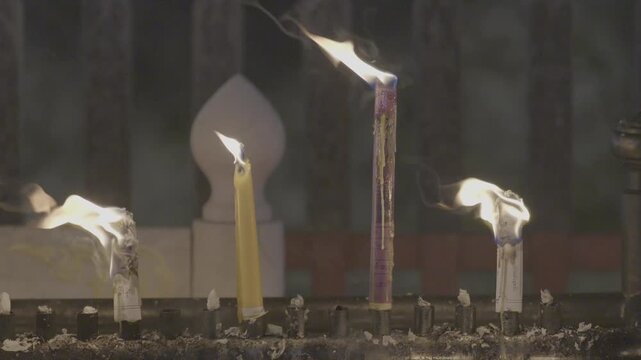 Lighting candles to worship Buddha statues in temples is a traditional Asian practice.