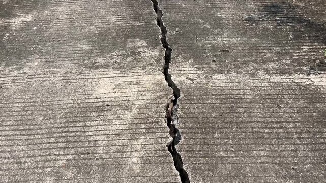 Deep crack on concrete road surface caused by earthquake