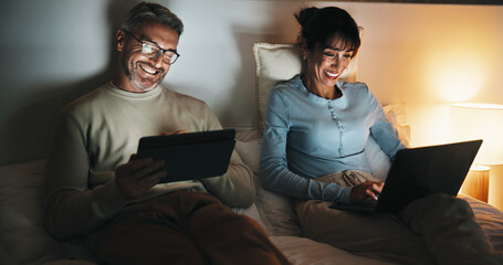 Bed, couple and streaming on tech at night for binge watching, bonding and funny tv show. Laptop, mature people or laugh with tablet in home for comedy film, web entertainment or healthy relationship © peopleimages.com