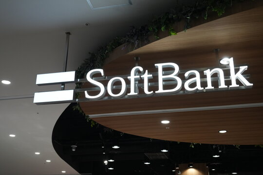 A glowing SoftBank logo sign inside a shopping mall in Japan.