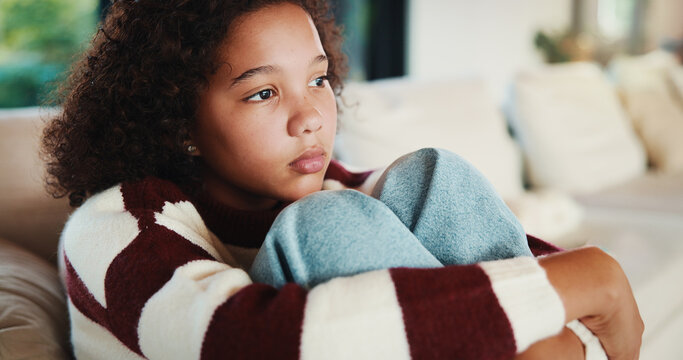 Unhappy, child and thinking on sofa, home and girl with low self esteem from bullying and bad memory. Remember, trauma and kid with anxiety, sadness and reflection on insecurity and mental health