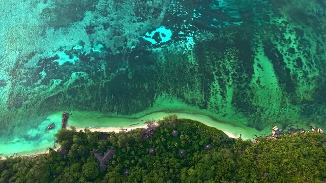 Aerial view of the tropical coastline near Praslin Ferry Harbour with turquoise water and coral reefs in Baie Ste Anne, Baie Sainte Anne, Seychelles.