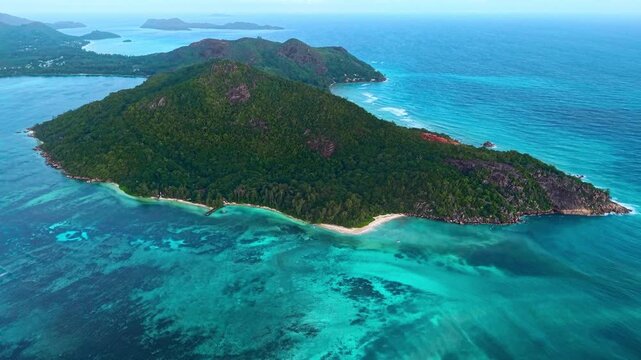 Aerial view of Praslin Ferry Harbour and the lush tropical coastline with turquoise coral reefs in Baie Ste Anne, Baie Sainte Anne, Seychelles.