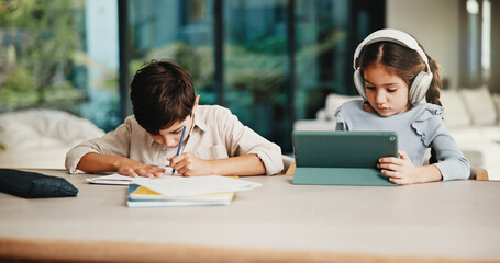 Homework, headphones and children in home with tablet, activity and project or academic app. Homeschool, tech and siblings in kitchen with document, digital lesson or assessment in remote education © peopleimages.com