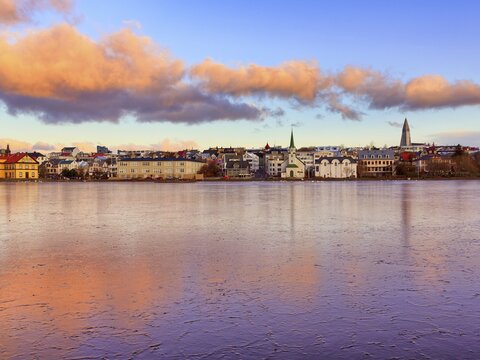 Frozen lake Tj&ouml;rnin in the city centre, cloud reflection at sunset, Reykjavik, Iceland