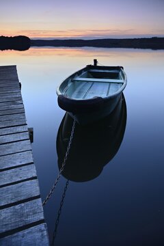 Quiet lake with jetty and rowing boat after sunset at dusk, Gro&szlig;er Lychensee, Lychen, Brandenburg, Germany