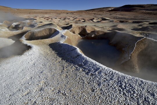 Geysers with water vapor frozen into ice flowers at edge, Sol de Ma&ntilde;ana geothermal field, Altiplano, Bolivia