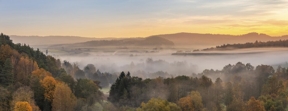 Landscape in Franconian Switzerland in autumn, view over colourful forests with morning mist at sunrise, Ahorntal, Franconian Switzerland, Upper Franconia, Bavaria, Germany