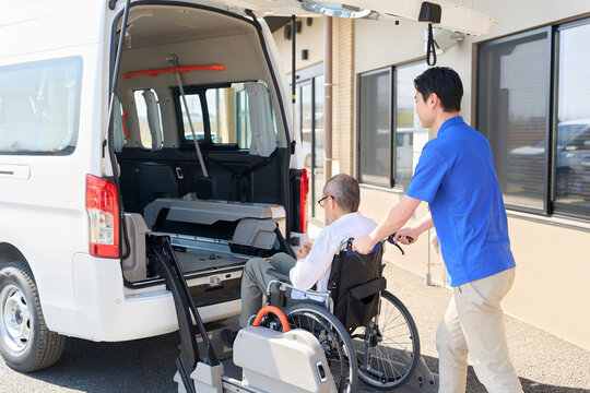 福祉車両に車椅子のシニアを乗せる介護士
