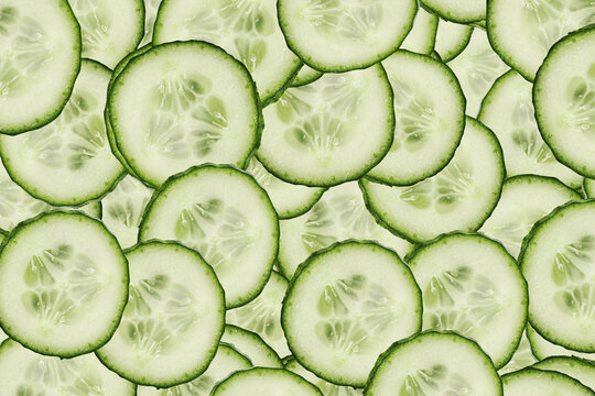 Fresh cucumber slices background. Green vegetable pattern close up. Healthy food texture with organic cucumber pieces. Natural vegan backdrop. Refreshing salad ingredient full frame composition