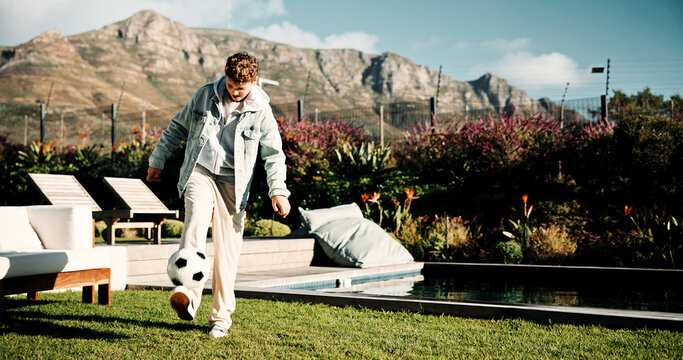 Football, ball and kick with child outdoor for playing, playoff practice and game drills. Soccer sport, match training and hobby with kid in backyard of home for growth, fun and footwork skill