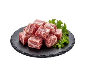 Fototapeta premium Fresh raw marbled beef cubes on a black round slate board isolated on white background