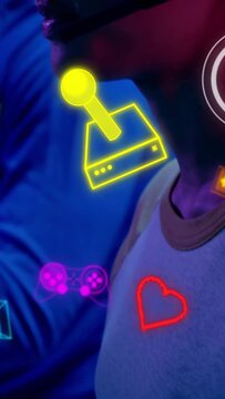 Vertical video: Team using pad right gamer talking into headset gaming icons over face for teamplay