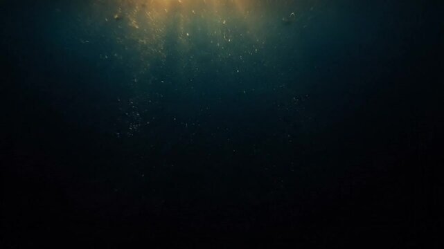 Underwater perspective showing sunlight beams penetrating the ocean depth revealing a dark mysterious scene