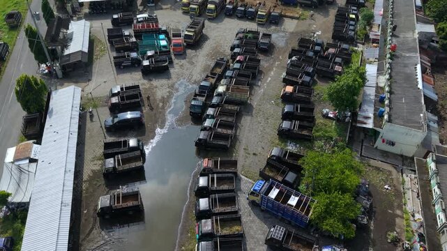 Aerial view of Animal Market Prambanan with rows of parked trucks and market stalls Kecamatan Prambanan, Jawa Tengah, Indonesia.