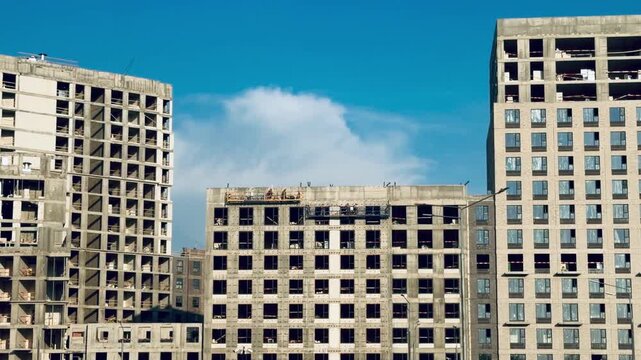 Construction process of Salaryevo Park residential complex by PIK group in Moscow, unfinished concrete buildings under blue sky, real estate industry development and modern block architecture.