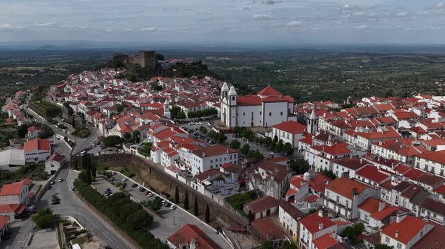 Aerial view of the Castle of Castelo de Vide and the historic town center with white houses and red roofs under a cloudy sky in Castelo de Vide, Portalegre, Portugal.