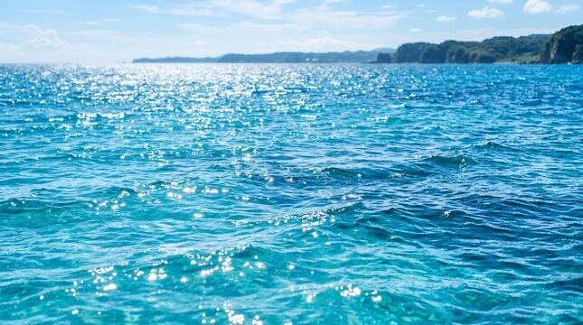 Sparkling Blue Ocean Water Surface with Sunlight Reflection and Distant Coastline
