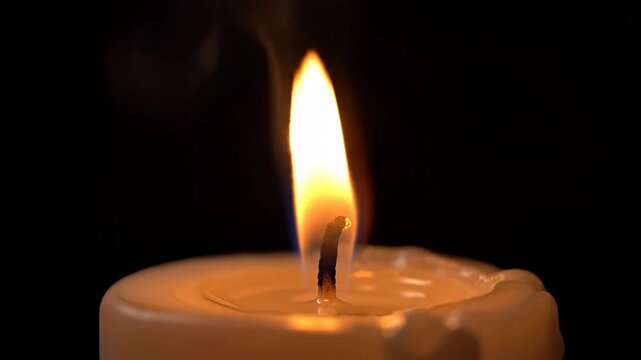 A single candle burns brightly alone.