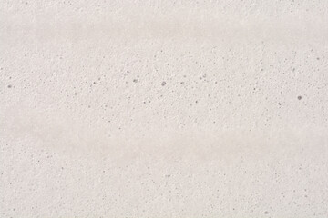 Fototapeta premium A close up shot captures a dense white foam surface filled with countless tiny uniform bubbles creating a soft abstract pattern.