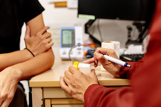 Medical doctor holding a sample specimen container talking with a patient in a clinic