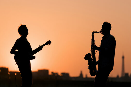 Silhouettes of street musicians playing guitar and saxophone at sunset during Fete de la Musique in France, illustrating live music, urban culture, and summer festival atmosphere