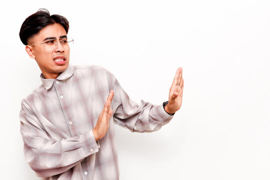 Disgusted Young Asian Man Showing Rejection Gesture with Both Hands Refusing Unpleasant Situation Isolated on White Background