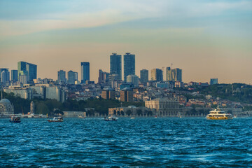 Obraz premium Panoramic View of the Istanbul City Skyline and Bosphorus Strait with Modern Skyscrapers, Traditional Architecture, and Boats Sailing on the Blue Sea at Sunset or Golden Hour