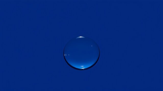 A single water droplet on a deep blue background with refracted light.