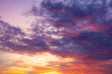 Obraz premium Vibrant Sunset Sky with Dramatic Clouds,A breathtaking view of a dramatic sunset with a vibrant mix of fiery orange, deep red, and rich purple hues painting the sky above the horizon, capturing.