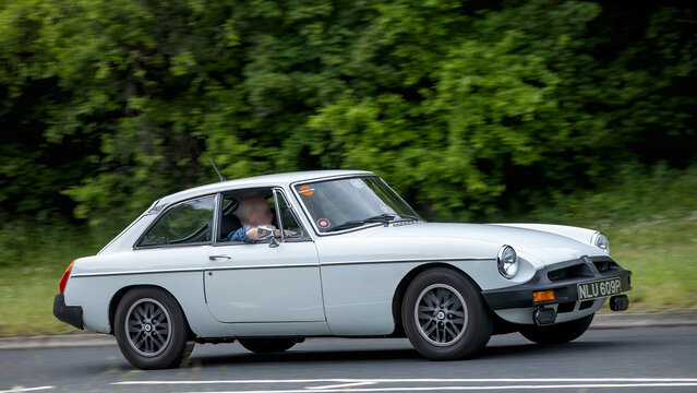 Milton Keynes,Bucks,UK - May 21st 2026:  1976 white MGB gt classic car driving on a British road