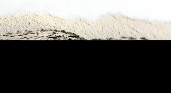 Close-up macro shot of torn textured paper stack showing layered fibers and rough edges on black background