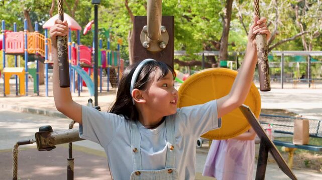 Young Asian Girl Exercising on Outdoor Fitness Equipment at Lumpini Park