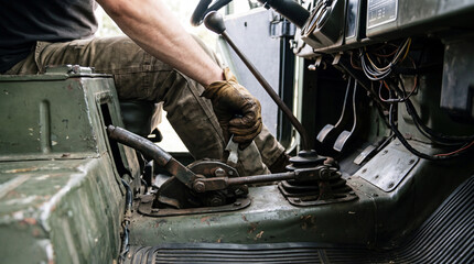 Close-up of a person operating a manual gear stick and handbrake in a rugged, vintage vehicle interior. © Laura