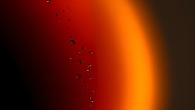 Close-up gradient of dark brown and amber liquid with tiny rising bubbles.