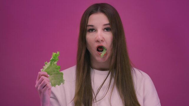 Young teen girl eating lettuce leaves, fresh healthy salad. Woman enjoying healthy food and clean eating lifestyle. Female have a organic vegetables, vegetarian diet concept, wellness, nutrition,