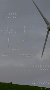 Vertical video: Tilt up causing turbine moving in blades turning binary overlay showing power