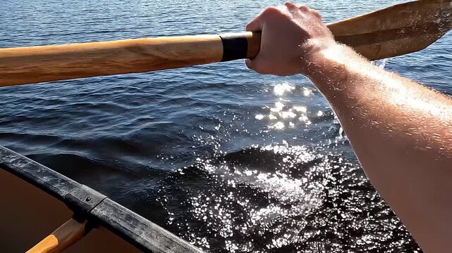 First Person View Rowing a Canoe with a Wooden Paddle on Sunny Lake