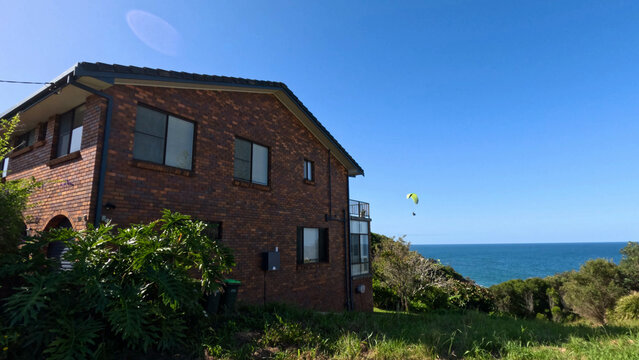 Paramotor Flying Over Coastal Brick House Near the Ocean in Australia