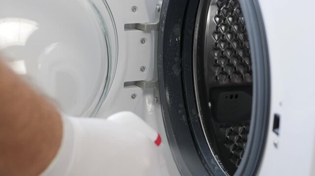 Man Doing Periodic Maintenance, Cleaning the Washing Machine. A Housekeeper Washing and Cleaning a Laundry Machine.