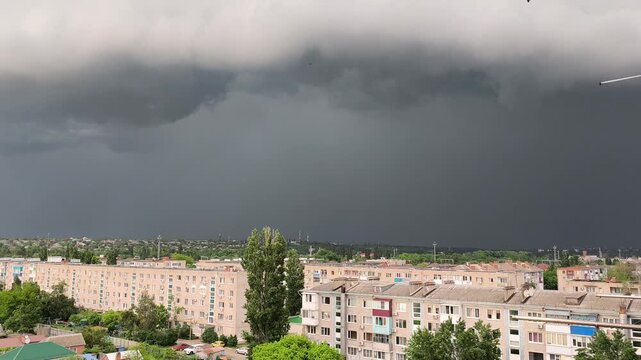 Dark stormy sky over city with lightning strikes and thunderclouds, summer storm approaching