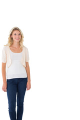 Fototapeta premium Woman in 20s standing left studio in white tank cream cardigan jeans gazing upper-right, copy space